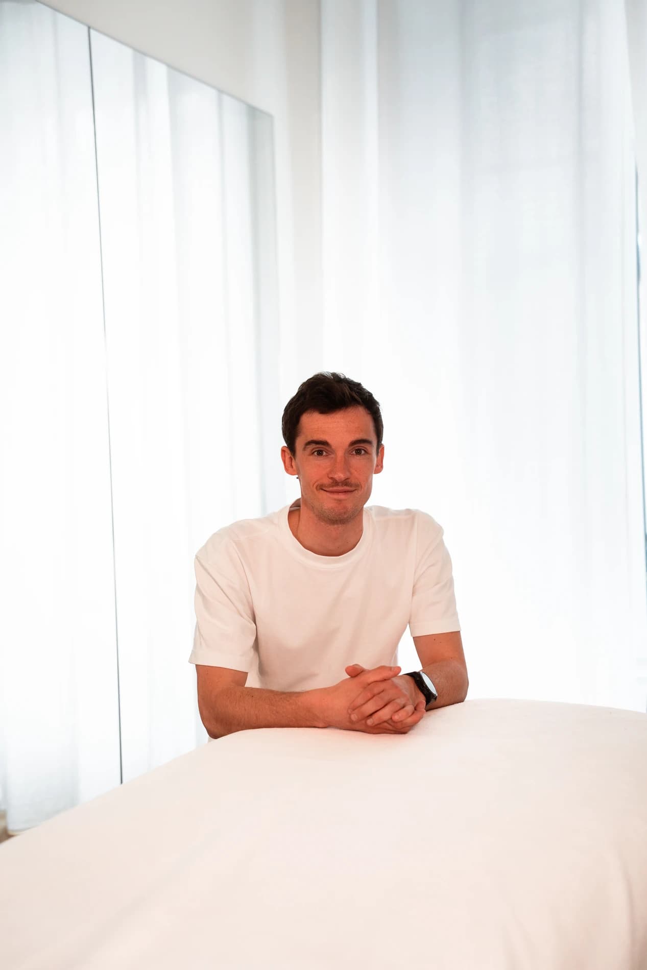 Portrait de Thomas Derême, physiothérapeute, à la table de soin de son cabinet